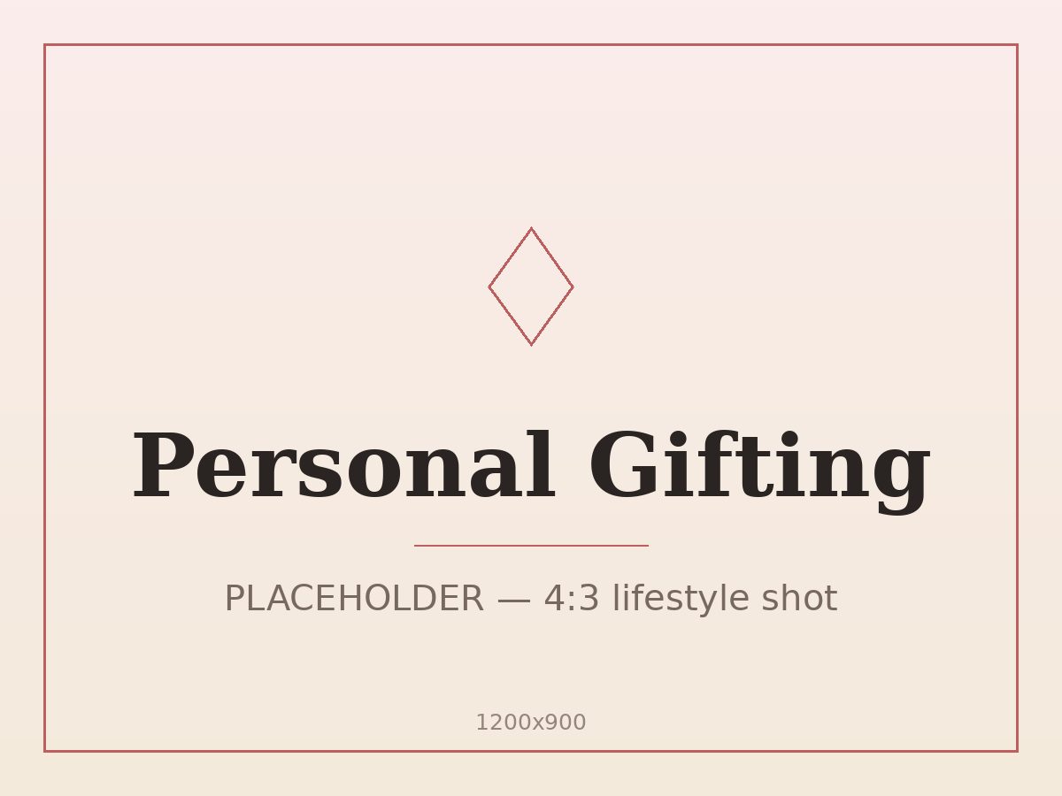 Personal gift box wrapped in blush paper with a red satin ribbon